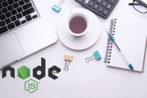 A workspace with a laptop, a cup of coffee, binder clips, a pen on a notebook, a calculator, and the Node.js logo on the desk.