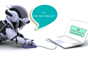 A robot uses a computer mouse while facing a laptop displaying a chat window; a speech bubble says, Hi! How may I help you?.
