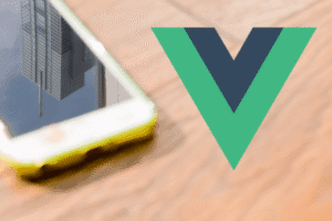 A smartphone with a building reflected on its screen sits next to the Vue.js logo on a wooden surface.